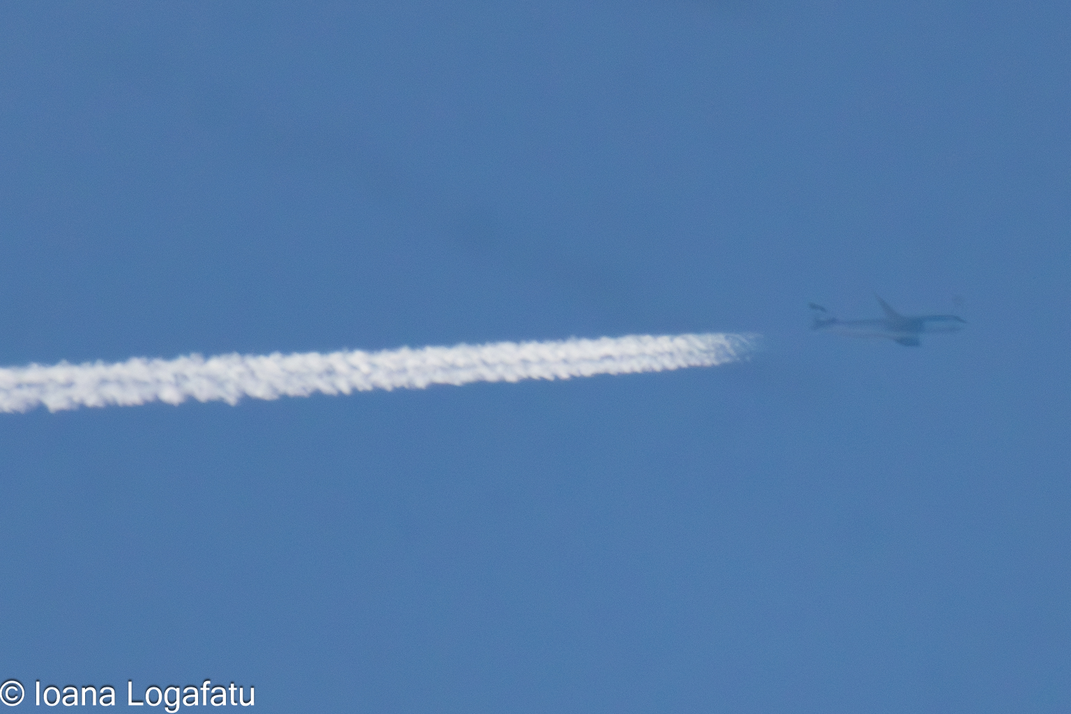 Jet trail marks cloudy horizon sky